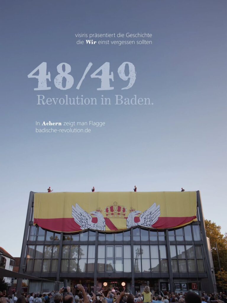 Die größte badische Flagge der Welt - über dem Rathaus Achern Manche Momente muss man einfach erleben. Im September haben wir in Achern die wohl größte badische Flagge der Welt gehisst: 325 Quadratmeter, rund 15 mal 25 Meter, hoch über dem alten Rathaus im geografischen Mittelpunkt Badens - Achern....